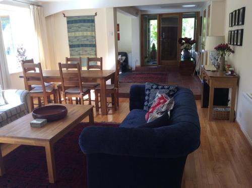 sala de estar con sofá azul y mesa en Trustwood Bed and Breakfast en Burton