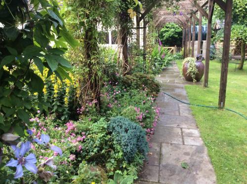 a garden with flowers and a pathway at Trustwood Bed and Breakfast in Burton