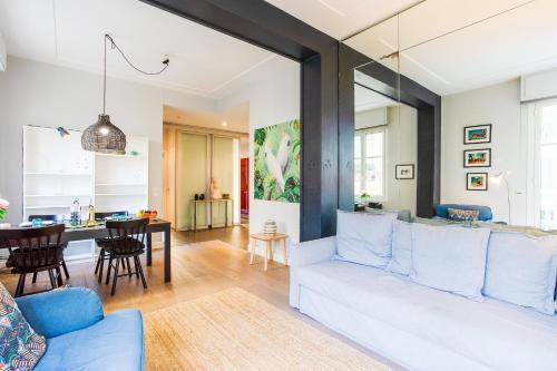 un salon avec un canapé blanc et une salle à manger dans l'établissement LE TIVOLI AP4264 By Riviera Holiday Homes, à Nice