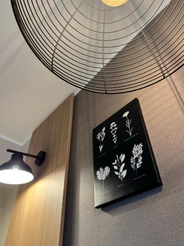 a picture of flowers on a wall next to a lamp at Draudzības alejas apartamenti in Jēkabpils