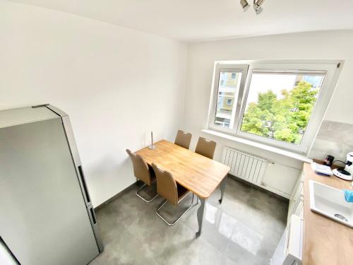 ein Esszimmer mit einem Holztisch und einem Fenster in der Unterkunft Zentral gelegene 2 Zi. Wohnung nähe Innenstadt/HBF in Wolfsburg