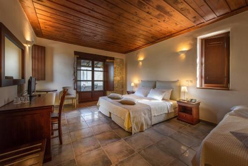 a bedroom with a bed and a desk and a television at Castello Antico Hotel in Gythio