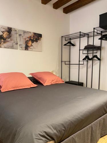 1 dormitorio con 1 cama con almohadas y estanterías de color naranja en Ca' degli Specchieri - A due passi da Piazza San Marco en Venecia