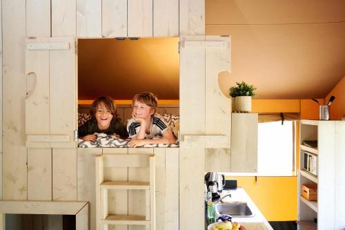 twee kinderen kijken uit een speelhuis bij Goorzicht in Aalten