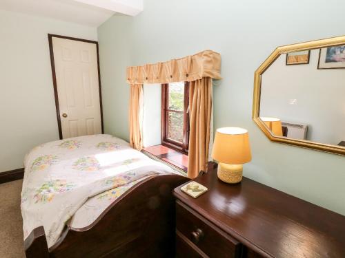 CliftonにあるChurch Farm Cottageのベッドルーム1室(ベッド1台、鏡、ドレッサー付)