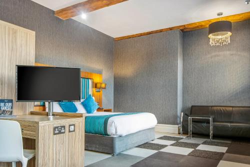 a hotel room with a bed and a flat screen tv at Roomzzz Manchester City in Manchester