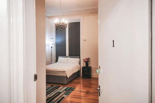 a bedroom with a bed and a chandelier at S.H Apartments in Glasgow