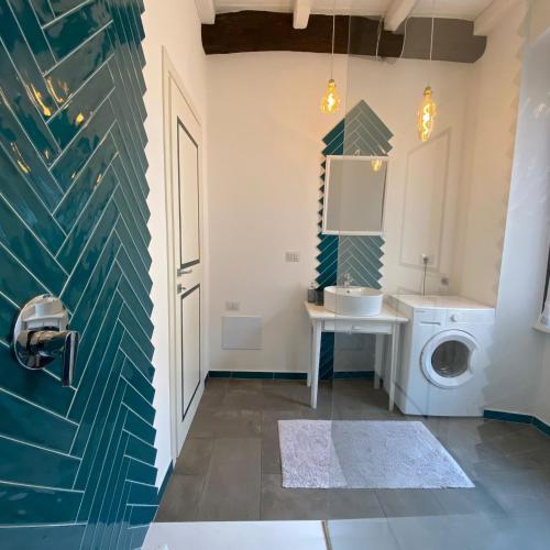 een badkamer met een wasmachine en een wastafel bij Appartamento Casaliva sul Garda in Pulciano