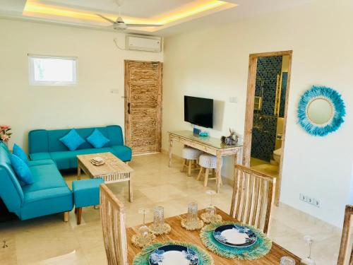 a living room with a blue couch and a table at Ocean Star Apartment Sanur in Sanur