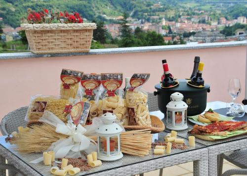 - une table avec de la nourriture et des bouteilles de vin et de fromage dans l'établissement Relais Black Horse, à Millesimo