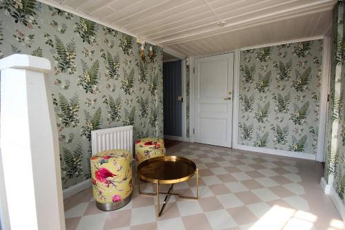 a room with floral wallpaper and a table and a chair at Riddersviks Herrgård in Stockholm