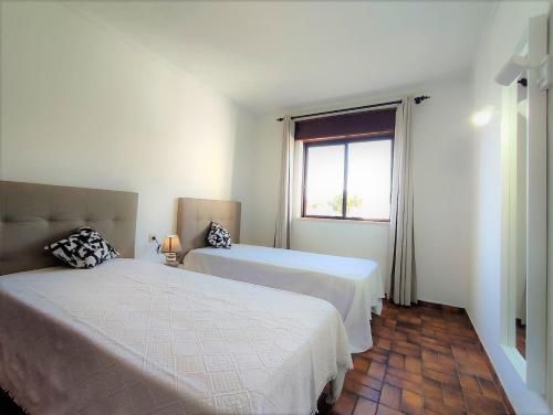 1 dormitorio con 2 camas y ventana en Apartamento V2 Pedro - By Bedzy, en Albufeira