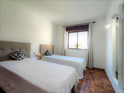 a bedroom with two beds and a window at Apartamento V2 Pedro - By Bedzy in Albufeira
