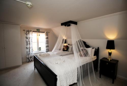 a bedroom with a bed with a mosquito net at Riddersviks Herrgård in Stockholm