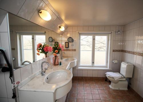 a bathroom with two sinks and a mirror and a toilet at Riddersviks Herrgård in Stockholm