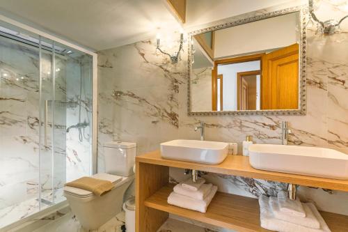 Un baño con lavabo, inodoro y espejo. en Casa di Flora Luxurious Apartment in Rhodes, en Rodas