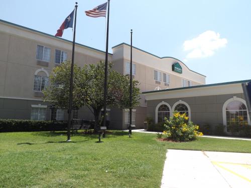 a building with two american flags in front of it at Wingate by Wyndham San Marcos in San Marcos