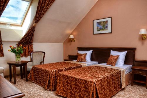 a hotel room with two beds and a window at Hotel Ventus Natural & Medical Spa in Gołdap