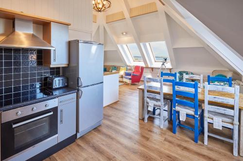 een keuken met een koelkast en een tafel met stoelen bij Host & Stay - The Watchtower in Bamburgh