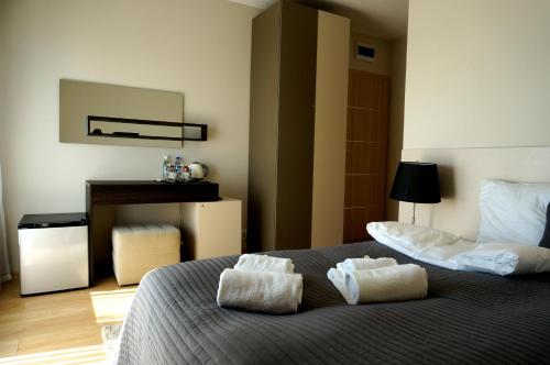 a bedroom with a bed with two towels on it at Villa Modlin Airport in Nowy Dwór Mazowiecki