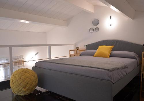 sypialnia z łóżkiem z żółtą poduszką w obiekcie The Court Suites & Spa w mieście Tarent