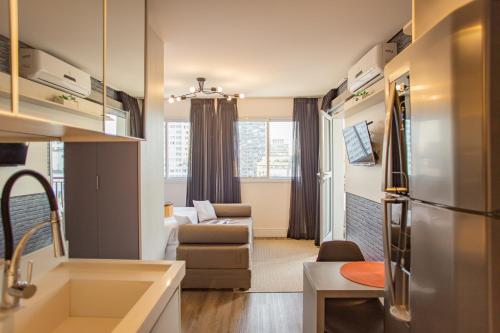 a small kitchen and living room with a refrigerator at Studios Centro SP 16 in Sao Paulo