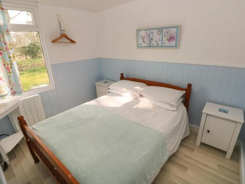 a small bedroom with a bed and a window at Shearwater Chalet in Haverfordwest