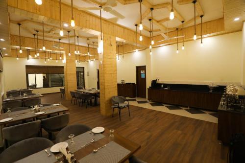 a dining room with tables and chairs and lights at Hotel Le Halcyon Kasauli in Solan