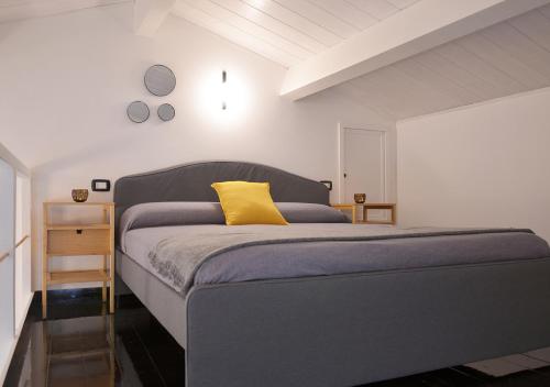 a bedroom with a bed with a yellow pillow on it at The Court Suites & Spa in Taranto