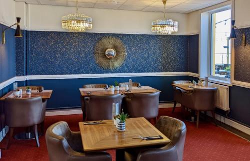 a dining room with wooden tables and chairs at The Beaches Hotel and Spa in Prestatyn