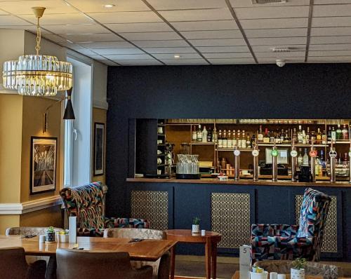 a restaurant with tables and chairs and a bar at The Beaches Hotel and Spa in Prestatyn