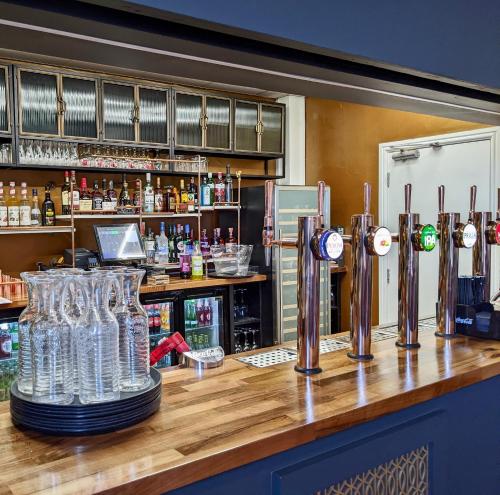 a bar with wine glasses on a wooden counter at The Beaches Hotel and Spa in Prestatyn