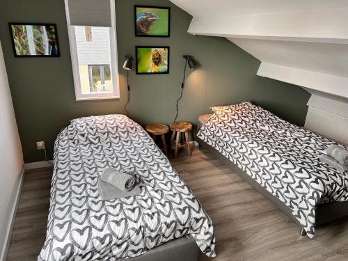 a bedroom with two beds and a staircase at Beach Life in De Cocksdorp