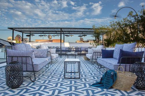 Le Pavillon de la Kasbah & SPA Marrakech في مراكش: فناء به كراسي زرقاء وبيضاء وطاولة