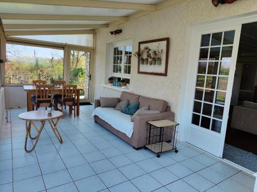 un salon avec un canapé et une table dans l'établissement Le Gîte d'Odette, à Dampierre-sous-Bouhy