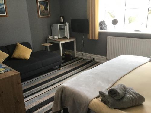a bedroom with a bed with a teddy bear on it at Torwood House in Penzance