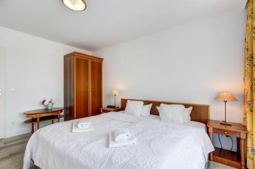 班辛海的住宿－Seehof Wohnung 1.33，卧室配有一张白色大床和两条毛巾