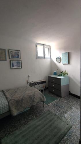 a bedroom with a bed and a dresser and a window at La Vannière in Le Poujol-sur-Orb