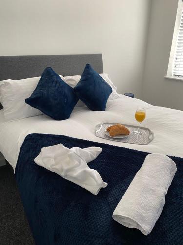 a bed with a plate of food and a glass of wine at HU-Thirteen Apt One - Sleeps 4 in Hessle