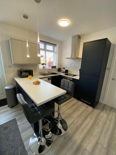 a kitchen with a table and two bar chairs at HU-Thirteen Apt One - Sleeps 4 in Hessle