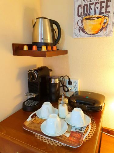 a table with plates and cups and a coffee maker at Virág Panzió in Lupeni