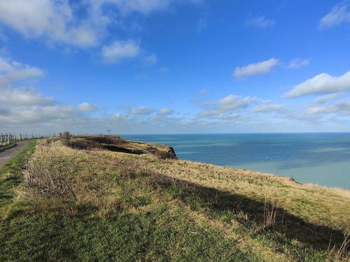 a grassy hill with the ocean in the background at Studio à la mer in Criel-sur-Mer
