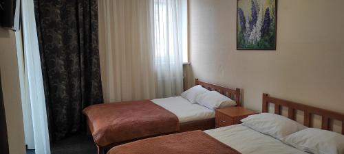 a hotel room with two beds and a window at Kozatskiy Hotel in Kyiv