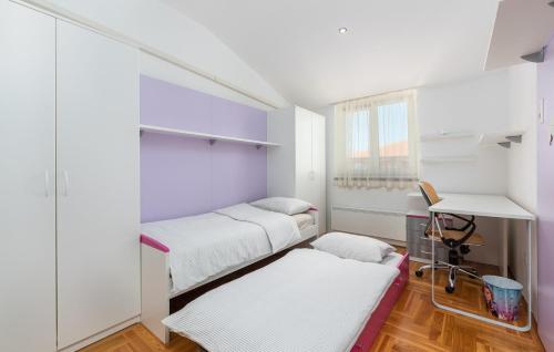 Habitación pequeña con 2 camas y escritorio. en Apartment MIA, en Tar