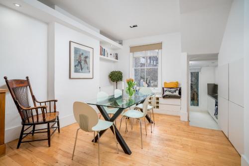 a dining room with a glass table and chairs at Captivating apartment in Shepherds Bush in London