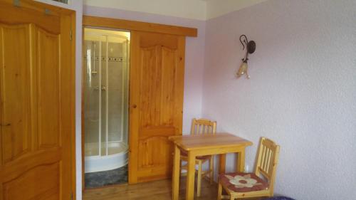 a room with a table and a wooden door at Penzion Apartmány Bečov in Bečov nad Teplou