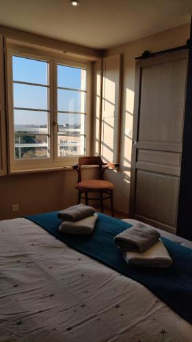 een slaapkamer met een groot bed met kussens erop bij Les coquelicots - Chambre Marie in Houdan