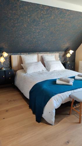 1 dormitorio con 1 cama grande con almohadas azules y blancas en Les coquelicots - Chambre Marie, en Houdan