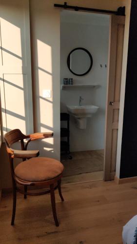 een badkamer met een stoel en een wastafel bij Les coquelicots - Chambre Marie in Houdan