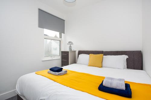a bedroom with a large bed with a yellow blanket at The Chase by Sorted Stay in Southend-on-Sea